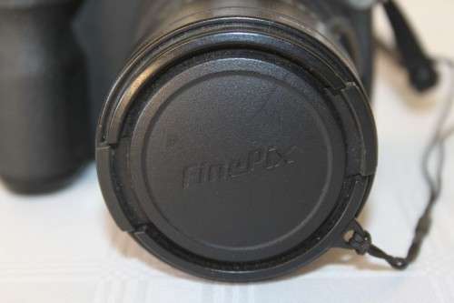 A Fujifilm FinePix S5000 Zoom with a strap in a high quality Lowepro bag