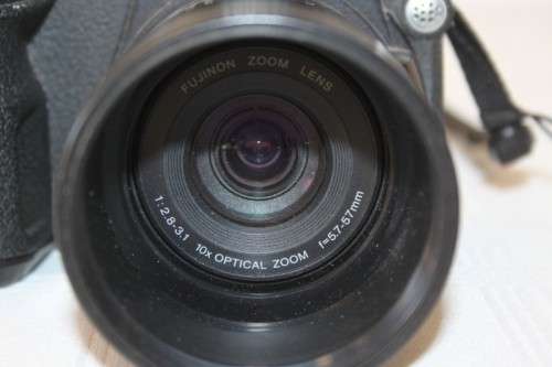 A Fujifilm FinePix S5000 Zoom with a strap in a high quality Lowepro bag