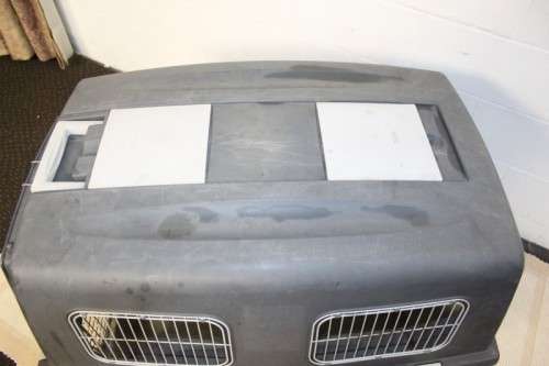 A large pet kennel/ travel case with two storage compartments on top