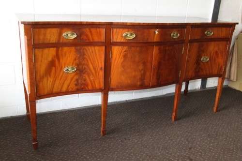 A magnificent Kingswood finished Regency buffet/ side server with spade feet and a curved front