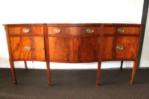 A magnificent Kingswood finished Regency buffet/ side server with spade feet and a curved front