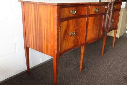 A magnificent Kingswood finished Regency buffet/ side server with spade feet and a curved front