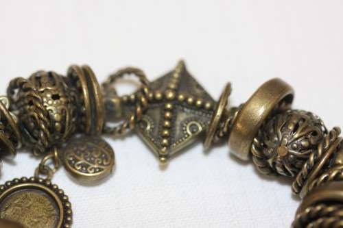 **RS17** A "chunky" ladies elasticised metal-beaded charm bracelet with an array of charms