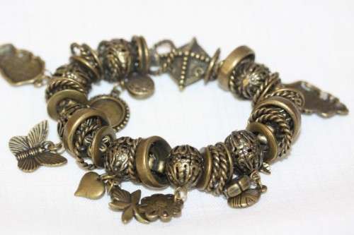 **RS17** A "chunky" ladies elasticised metal-beaded charm bracelet with an array of charms