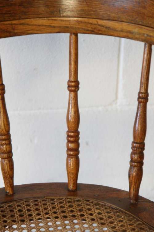 A magnificent Edwardian antique solid oak tub chair with a wicker bottom - very collectable!