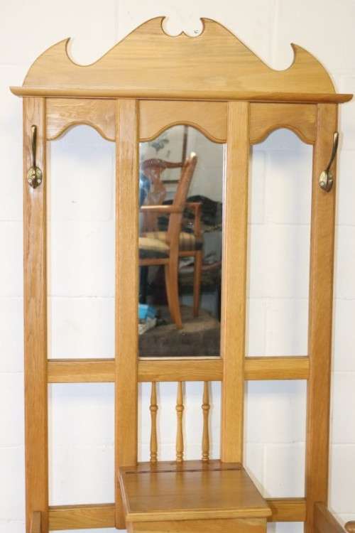 A stunning tall oak hall stand with a beveled mirror, storage box and 2 hooks in great condition.