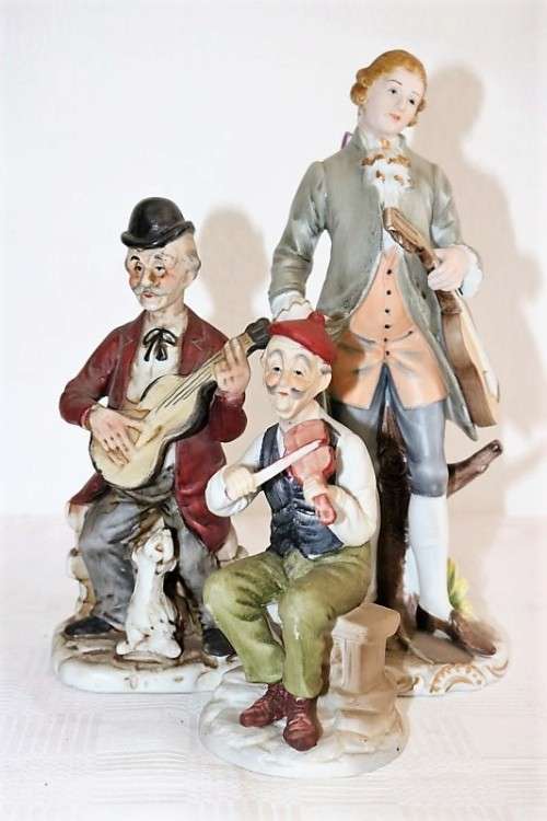 Three wonderful ceramic figurines of men with musical instruments with hand painted detailing