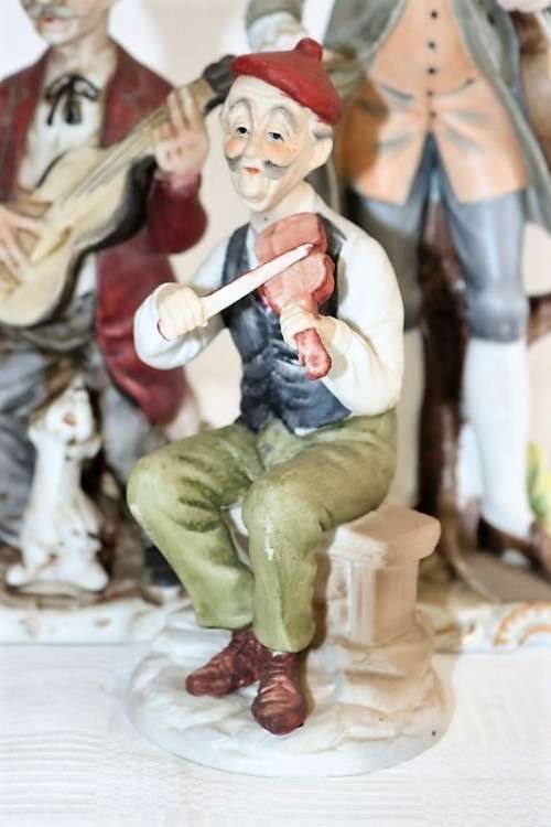 Three wonderful ceramic figurines of men with musical instruments with hand painted detailing