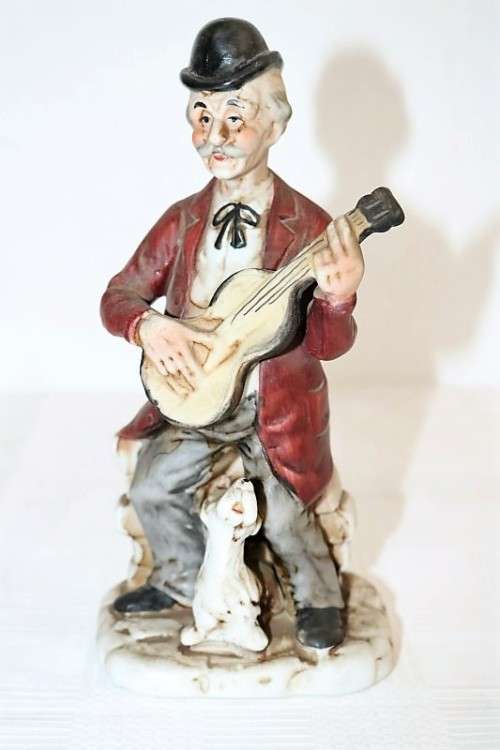 Three wonderful ceramic figurines of men with musical instruments with hand painted detailing
