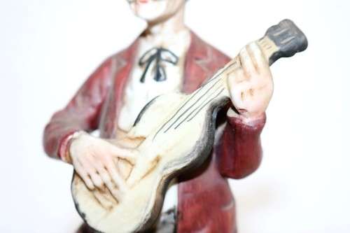 Three wonderful ceramic figurines of men with musical instruments with hand painted detailing