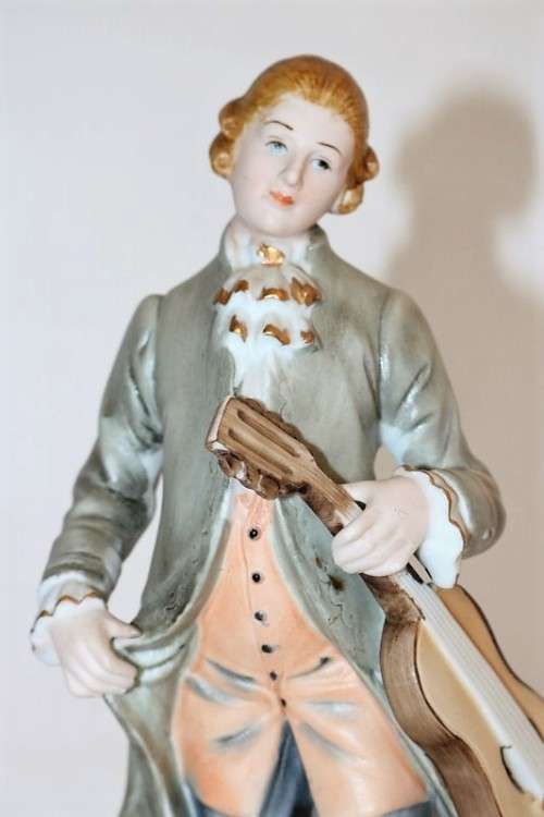 Three wonderful ceramic figurines of men with musical instruments with hand painted detailing