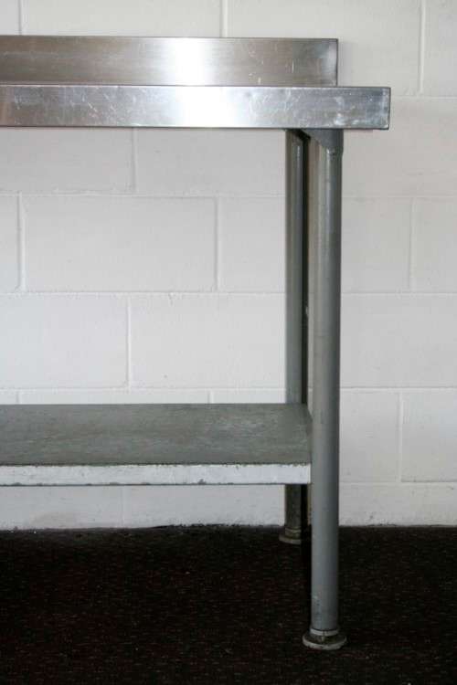 A fantastic (1.68m) stainless steel catering table with splash-back and galvanised storage shelf