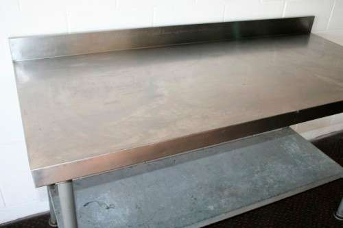 A fantastic (1.68m) stainless steel catering table with splash-back and galvanised storage shelf