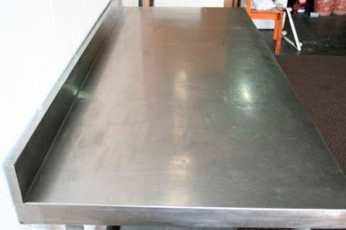 A fantastic (1.68m) stainless steel catering table with splash-back and galvanised storage shelf