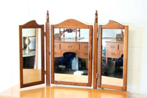 An exquisite two-drawer yellow wood & imbuia side-folding mirror dressing table with a riempie stool