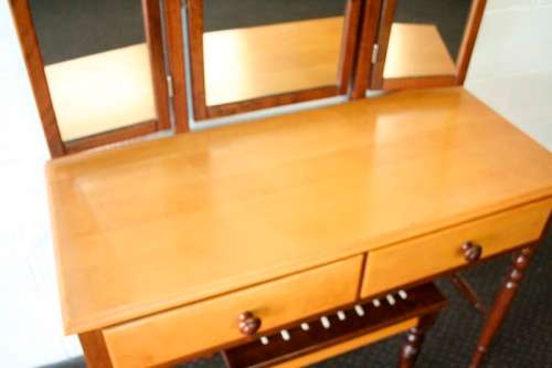 An exquisite two-drawer yellow wood & imbuia side-folding mirror dressing table with a riempie stool