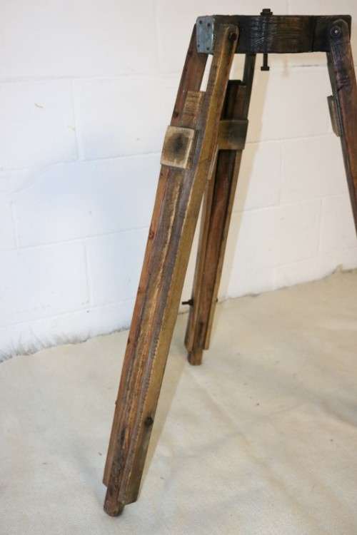 A fantastic antique metal and wood surveyor tripod in good condition for its impressive age
