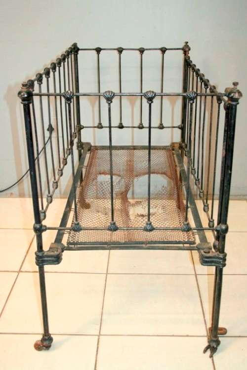 A stunning & rare antique (late 1800's) wrought iron baby's cot w/ dropside on its original castors