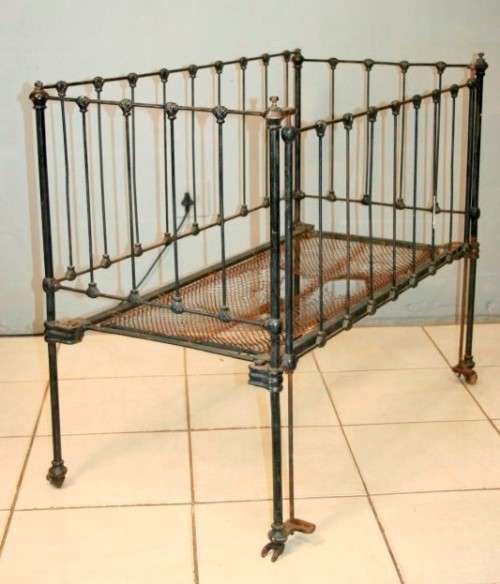 A stunning & rare antique (late 1800's) wrought iron baby's cot w/ dropside on its original castors