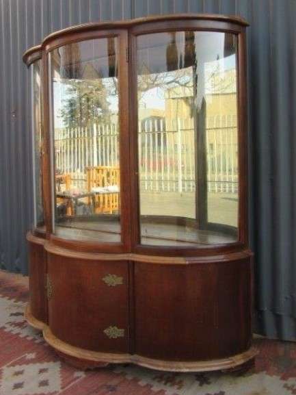A stunning and beautifully made curved glass Teak show cabinet with solid brass embellishments