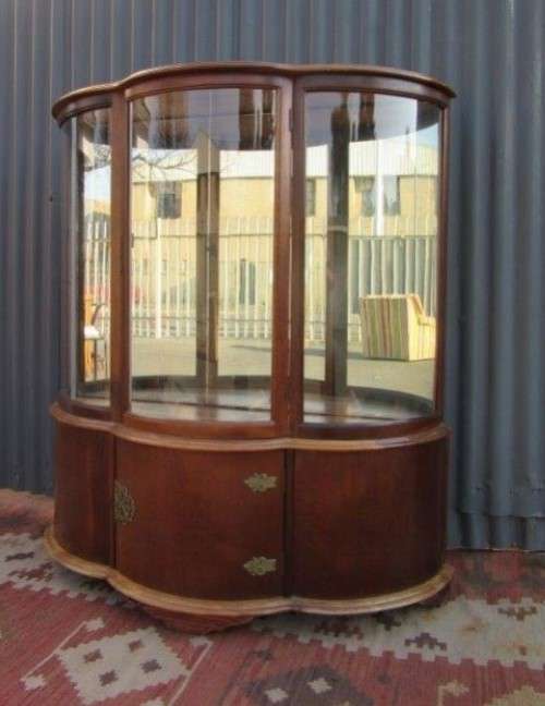 A stunning and beautifully made curved glass Teak show cabinet with solid brass embellishments