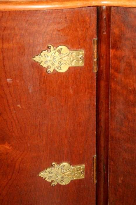 A stunning and beautifully made curved glass Teak show cabinet with solid brass embellishments