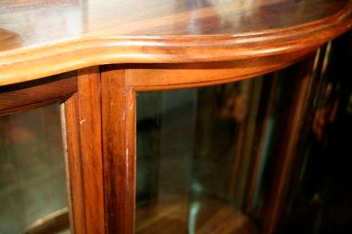 A stunning and beautifully made curved glass Teak show cabinet with solid brass embellishments