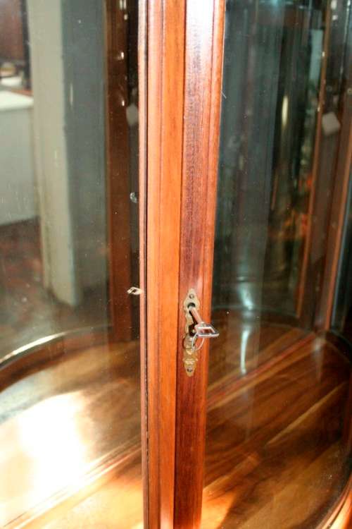A stunning and beautifully made curved glass Teak show cabinet with solid brass embellishments
