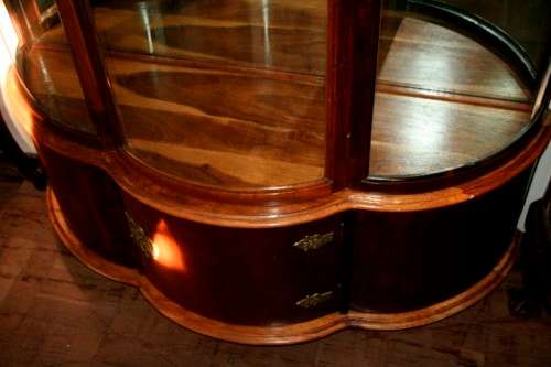 A stunning and beautifully made curved glass Teak show cabinet with solid brass embellishments