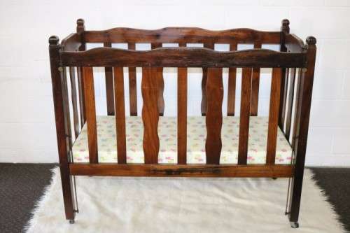 An awesome vintage solid Imbuia baby's cot on its original castors - perfect for nursery