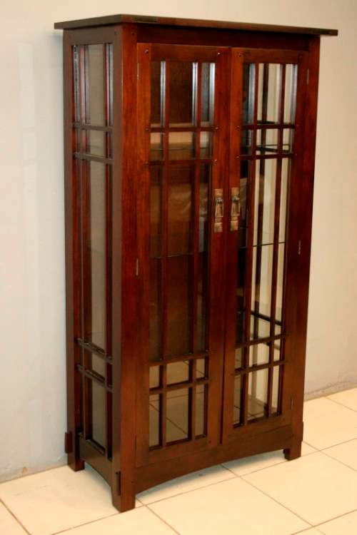 An incredibly well made solid Indonesian teak cabinet with glass shelves and beautiful slatted doors