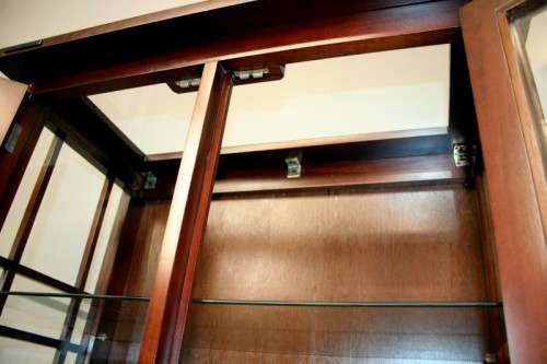 An incredibly well made solid Indonesian teak cabinet with glass shelves and beautiful slatted doors