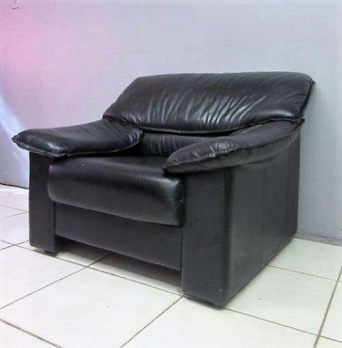 A beautiful well made black genuine leather single sofa with padded armrests & comfortable seating!!
