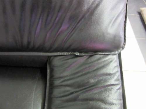 A beautiful well made black genuine leather single sofa with padded armrests & comfortable seating!!