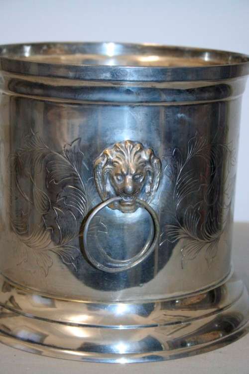 A stunning silver plated wine cooler with beautiful engraved detailing and lion-head ring handles