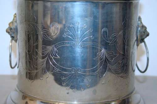A stunning silver plated wine cooler with beautiful engraved detailing and lion-head ring handles