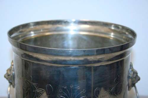 A stunning silver plated wine cooler with beautiful engraved detailing and lion-head ring handles