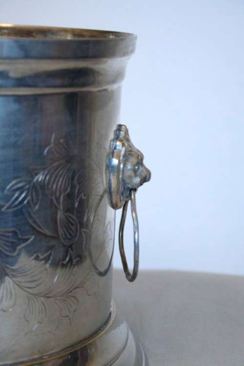 A stunning silver plated wine cooler with beautiful engraved detailing and lion-head ring handles