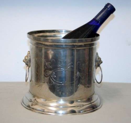 A stunning silver plated wine cooler with beautiful engraved detailing and lion-head ring handles