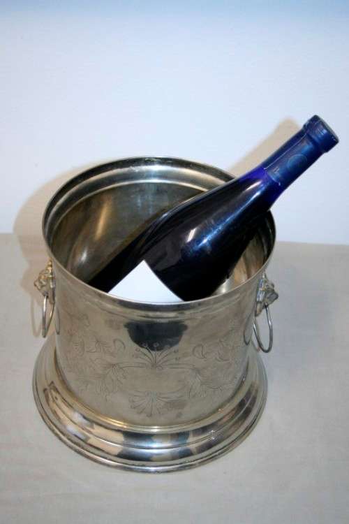 A stunning silver plated wine cooler with beautiful engraved detailing and lion-head ring handles