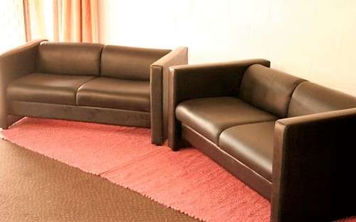 An awesome and stylish black bonded leather 2-seater "Tuxedo" couch in great condition