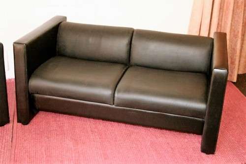 An awesome and stylish black bonded leather 2-seater "Tuxedo" couch in great condition