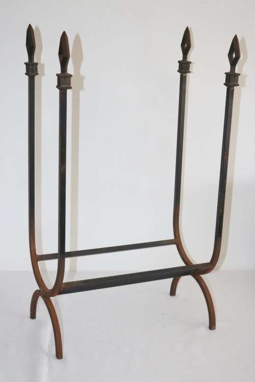An awesome and well made wrought iron fireplace log holder with stunning "arrow" finials