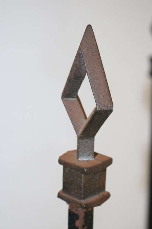 An awesome and well made wrought iron fireplace log holder with stunning "arrow" finials
