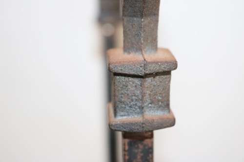 An awesome and well made wrought iron fireplace log holder with stunning "arrow" finials