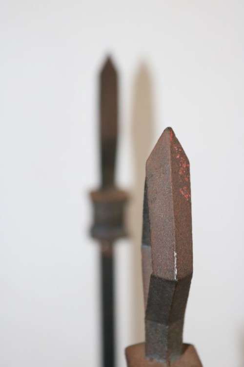 An awesome and well made wrought iron fireplace log holder with stunning "arrow" finials