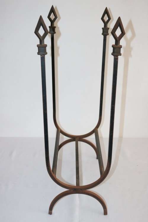 An awesome and well made wrought iron fireplace log holder with stunning "arrow" finials