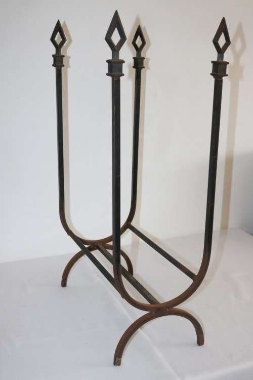 An awesome and well made wrought iron fireplace log holder with stunning "arrow" finials