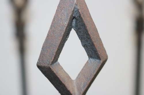 An awesome and well made wrought iron fireplace log holder with stunning "arrow" finials