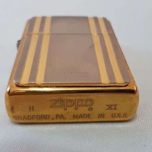 A stunning gold and silver detailed retro style authentic Zippo lighter in its original box
